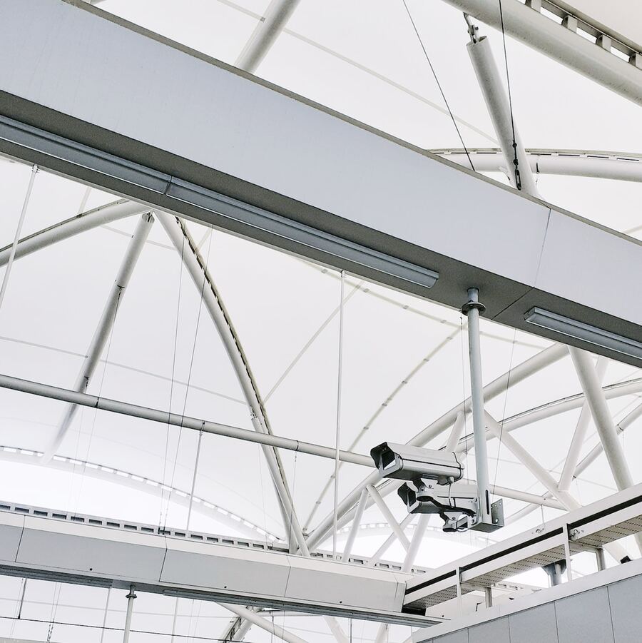 CCTV camera mounted on the steel roof structure of a commercial building